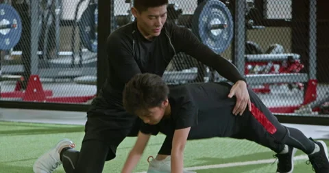 Active Chinese boy having exercise class with coach in gym,4K Stock Footage 156632587