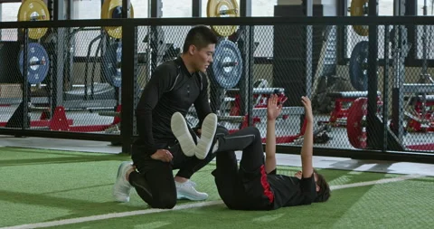 Active Chinese boy having exercise class with coach in gym,4K Stock Footage 156632816