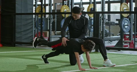 Active Chinese boy having exercise class with coach in gym,4K Stock Footage 156634502
