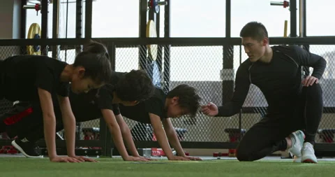 Active Chinese children having exercise class with their coach in gym,4K Stock Footage 156586358