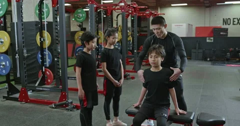 Active Chinese children having exercise class with their coach in gym,4K Stock Footage 156601514