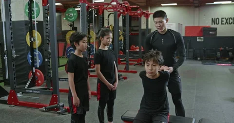 Active Chinese children having exercise class with their coach in gym,4K Stock Footage 156602081