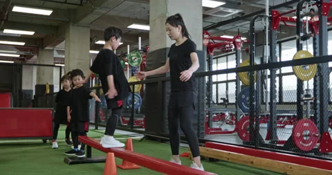 Active Chinese children having exercise class with their coach in gym,4K Stock Footage 156605342
