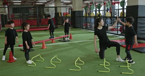 Active Chinese children having exercise class with their coach in gym,4K Stock Footage 156620897