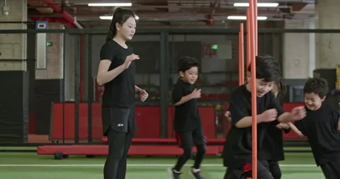 Active Chinese children having exercise class with their coach in gym,4K Stock Footage 156623310