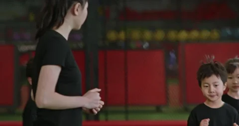 Active Chinese children having exercise class with their coach in gym,4K Stock Footage 156624883