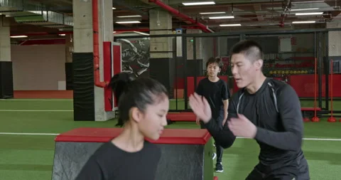 Active Chinese children having exercise class with their coach in gym,4K Stock Footage 156637488