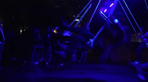 Active citizen people roll on rope swing on neon light at night. 4K Stock Footage 56934914