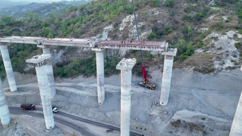 Active civil engineering: Crane lifting materials onto bridge pillars. Stockbeeldmateriaal 335643811