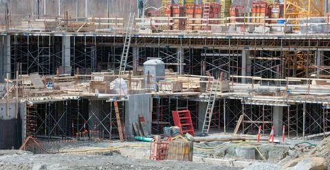 Active construction site with scaffolding, ladders, and concrete formwork Stock Photos