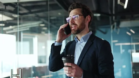Active corporate worker having phone conversation with paper cup of coffee 스톡 동영상 271298132