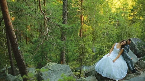 Active couple climbing on the rock in the forest with cliffs, pine trees Stock Footage 95835271