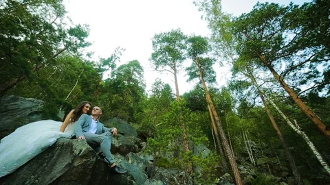 Active couple climbing on the rock in the forest with cliffs, pine trees Stock Footage 95838533