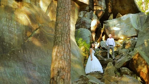 Active couple climbing on the rock in the forest with cliffs, pine trees Stock Footage 95841754