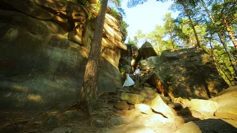 Active couple climbing on the rock in the forest with cliffs, pine trees Stock Footage 95842516