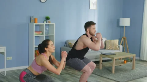 Active Couple Is Doing Squats at Home Vídeos de archivo 132018199