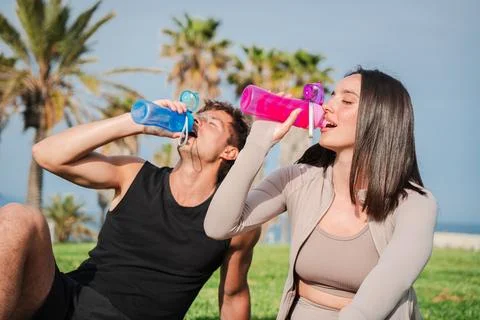 Active couple enjoying refreshing drinks while relaxing and rehydrating during Stock Photos