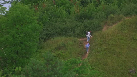 Active couple of tourists walking on date outdoors, hiking on rough green hills Stock Footage 164726840
