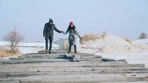 Active couple walking on the bridge of planks, a beautiful winter sunny day Stock Footage 70992606