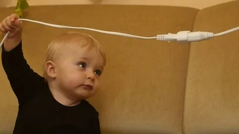 Active cute 9-10 months old baby boy breaks electric wire slow motion Stock Footage 82780428