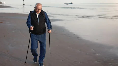 Active elderly 70s man training walking stick contemplating sea sunset landscape Видео 220022002