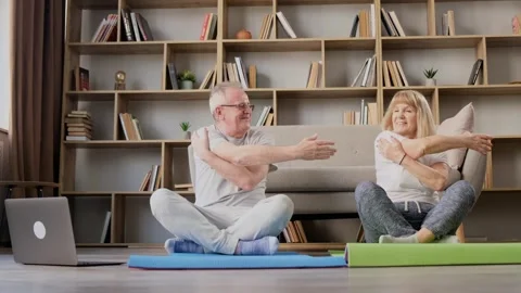 Active elderly couple doing exercises and watching online exercise tutorials on Video stock 257127255