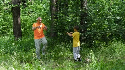 Active elderly man and little boy practicing kicks in nature background Stock-Footage 314494142