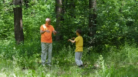 Active elderly man and little boy kicking in nature background Stock Footage 314494144