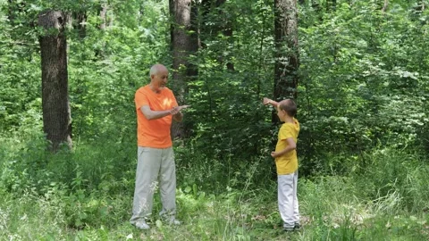 Active elderly man and little boy practicing blocks and strikes Stock Footage 314494410