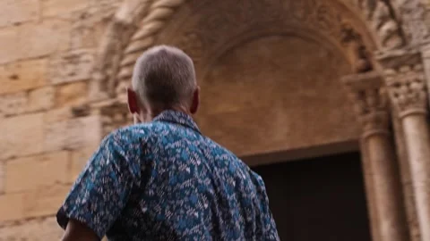 Active elderly man walking in medieval historic European town, taking a photo Stock Footage 316685530