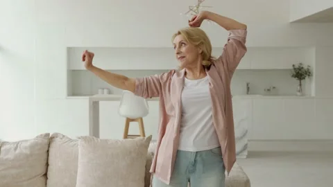 An active elderly woman doing pilates at home, trains in the living room Stock Footage 161695489