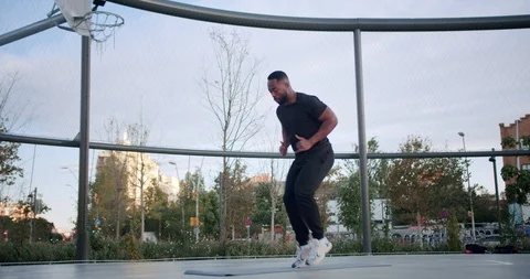 Active energetic African American tense man exercising alone at sport ground in Stock Footage 123665515