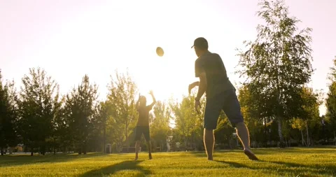 Active father and son play rugby in sunny park. Sporty father throws ball to son Video stock 328706423