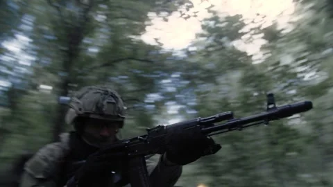 Active fighting in a dense forest, an armed soldier with a machine gun Stock Footage 327447508