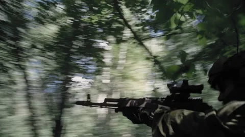 Active fighting in a dense forest, an armed soldier with a machine gun Stock Footage 327447583