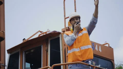 Active Foreman in Building Construction raising hand and radio to orders Stock Footage 159277917