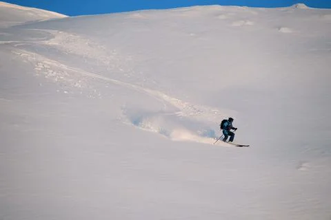 Active freerider rides down white powdery snow of mountain slope 스톡 사진