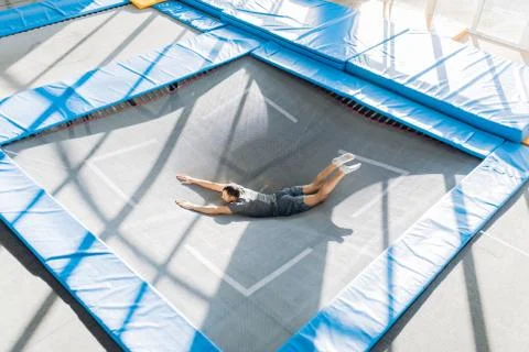 Active funny man bouncing on trampoline along Stock Photos