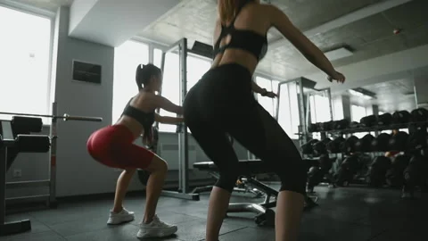 Active girls doing squat exercises at modern gym Stock Footage 133700027