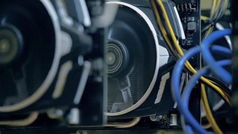 Active graphics card fan and blue cable inside open GPU mining rig Stock Footage 343916281