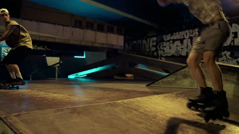 Active hipsters performing jump trick on ramp at night skate park with graffiti. Stock Footage 171304375