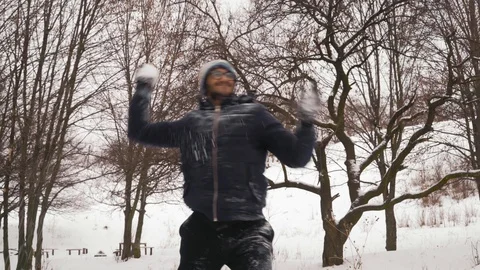 Active Indian Guy in Glasses Throws Snowballs in the Park Vidéo 101591169