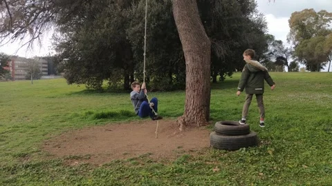 Active kid boy swing on homemade bungee Stock Footage 252507161