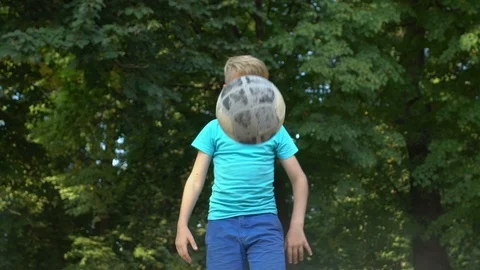 Active kid kicking up old soccer ball, hit improvement, street football training Vídeos de archivo 117166317