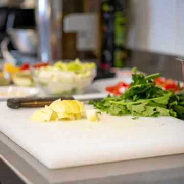Active kitchen prep scene showing raw ingredients and cooking Stock Photos