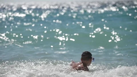 Active little boy in diving mask playing with huge waves in blue storm sea Vídeo Stock 158835242