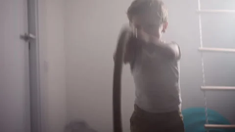 Active little boy does effective exercise with battle rope Stock Footage 243309159