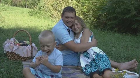 Active little boy playing on the background of hugging dad and mom on the grass 스톡 동영상 110466845