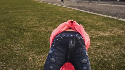 Active little girl doing backbend on green grass Stockbeeldmateriaal 160815820