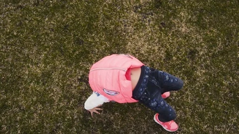 Active little girl doing backbend on green grass Stockbeeldmateriaal 160816122